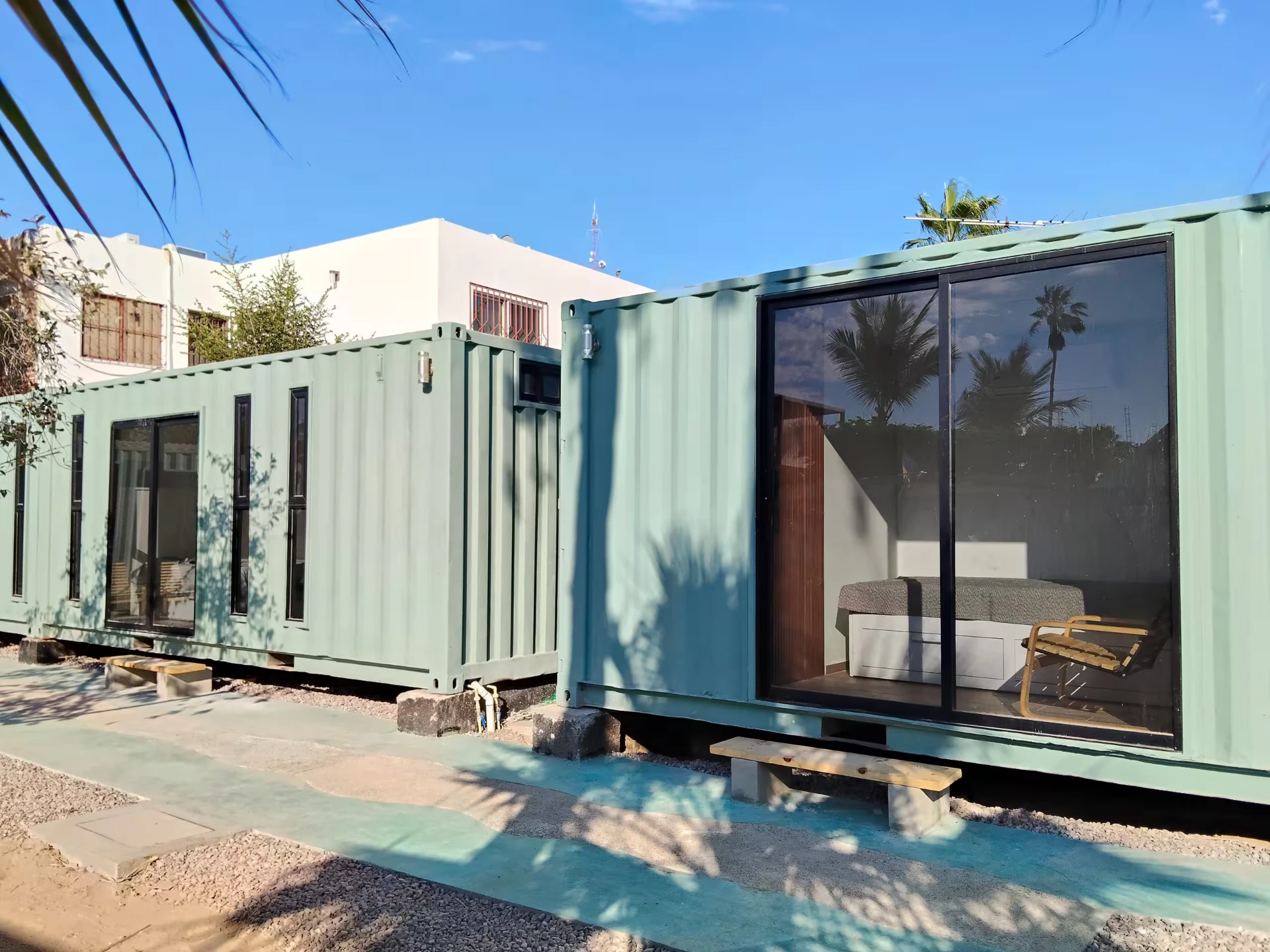 Espacios tipo contenedor de Villa Ballena con ventanal y palmeras, hospedaje tranquilo a unas cuadras del IMSS en La Paz, BCS